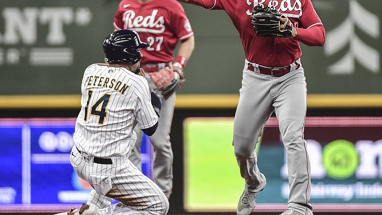 Jul 11, 2021; Milwaukee, Wisconsin, USA; Milwaukee Brewers second baseman Jace Peterson (14) breaks up a double play attempt by Cincinnati Reds third baseman Eugenio Suarez (7) in the second inning at American Family Field. Mandatory Credit: Benny Sieu-USA TODAY Sports