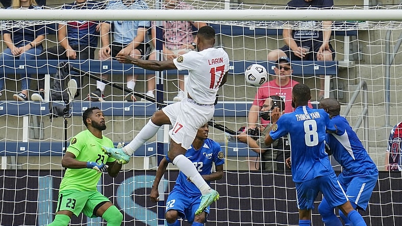 Jul 11, 2021; Kansas City, Kansas, USA; Canada forward Cyle Larin (17) scores a goal against Martinique goalkeeper Meslien Gilles (23) in the first half during a CONCACAF Gold Cup group stage soccer match at Children's Mercy Park. Mandatory Credit: Jay Biggerstaff-USA TODAY Sports
