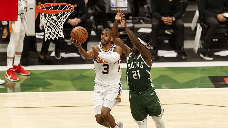 Jul 11, 2021; Milwaukee, Wisconsin, USA; Phoenix Suns guard Chris Paul (3) drives for a layup against Milwaukee Bucks guard Jrue Holiday (21) during the third quarter during game three of the 2021 NBA Finals at Fiserv Forum. Mandatory Credit: Jeff Hanisch-USA TODAY Sports