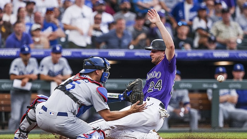 Jul 17, 2021; Denver, Colorado, USA; Colorado Rockies second baseman Ryan McMahon (24) slides past Los Angeles Dodgers catcher Austin Barnes (15) to score a run in the second inning at Coors Field. Mandatory Credit: Michael Ciaglo-USA TODAY Sports