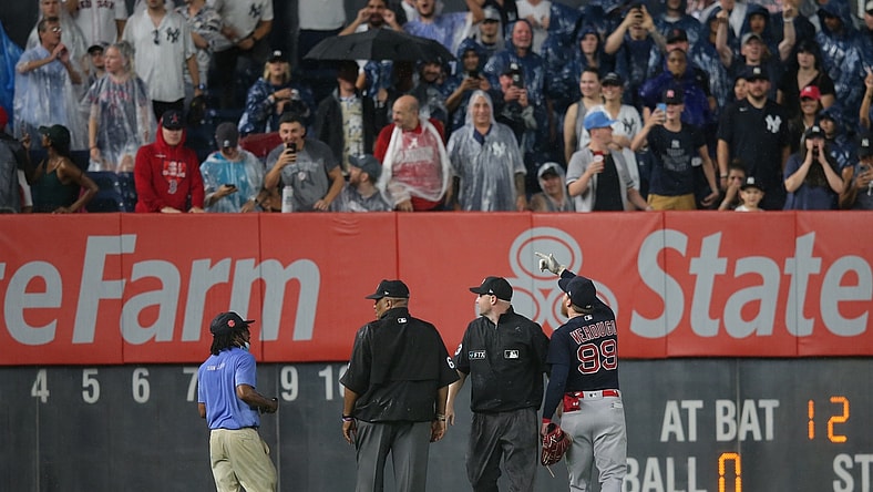 Jul 17, 2021; Bronx, New York, USA; Boston Red Sox left fielder Alex Verdugo (99) points out to second base umpire Mike Estabrook (83) and third base umpire Laz Diaz (63) a fan who threw an object at him to during the sixth inning against the New York Yankees at Yankee Stadium. Mandatory Credit: Brad Penner-USA TODAY Sports