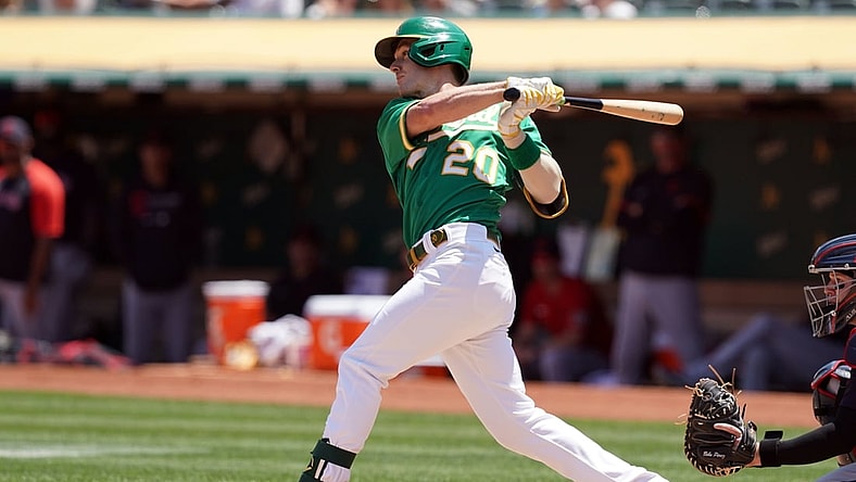 Jul 18, 2021; Oakland, California, USA; Oakland Athletics left fielder Mark Canha (20) hits a single during the third inning against the Cleveland Indians at RingCentral Coliseum. Mandatory Credit: Darren Yamashita-USA TODAY Sports