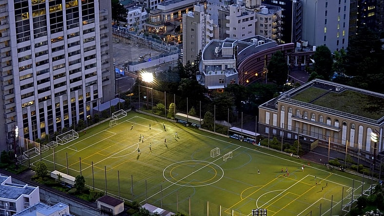 Jul 20, 2021; Tokyo, Japan; People play soccer on a field near the Tokyo Tower before the Tokyo 2020 Summer Olympic Games. Mandatory Credit: Peter Casey-USA TODAY Network