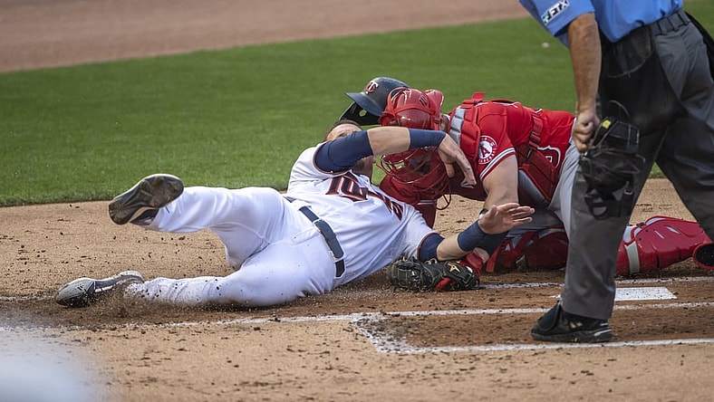 Jul 22, 2021; Minneapolis, Minnesota, USA; Minnesota Twins left fielder Trevor Larnach (24) gets tagged out at home plate from Los Angeles Angels catcher Max Stassi (33) in the second inning at Target Field. Mandatory Credit: Jesse Johnson-USA TODAY Sports