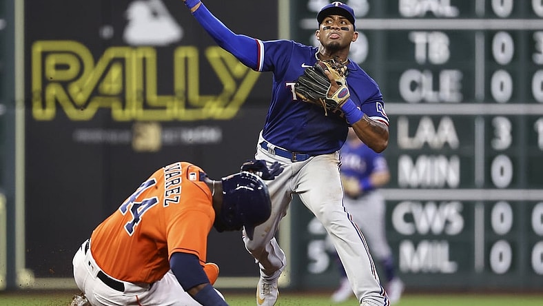 Jul 23, 2021; Houston, Texas, USA; Houston Astros designated hitter Yordan Alvarez (44) is out at second base as Texas Rangers second baseman Andy Ibanez (77) throws to first base during the third inning at Minute Maid Park. Mandatory Credit: Troy Taormina-USA TODAY Sports