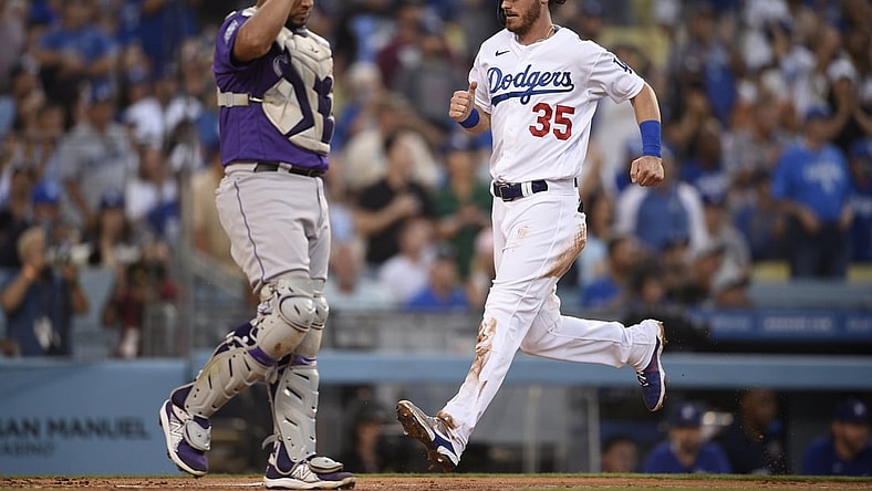 Jul 23, 2021; Los Angeles, California, USA; Los Angeles Dodgers center fielder Cody Bellinger (35) scores as Colorado Rockies catcher Elias Diaz (35) looks on during the first inning at Dodger Stadium. Mandatory Credit: Kelvin Kuo-USA TODAY Sports