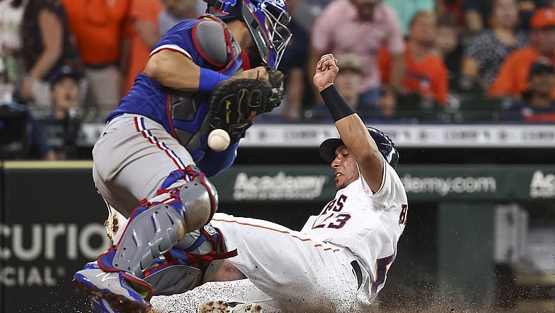 Jul 24, 2021; Houston, Texas, USA; Houston Astros designated hitter Michael Brantley (23) scores a run as Texas Rangers catcher Jose Trevino (23) attempts to field a throw during the third inning at Minute Maid Park. Mandatory Credit: Troy Taormina-USA TODAY Sports