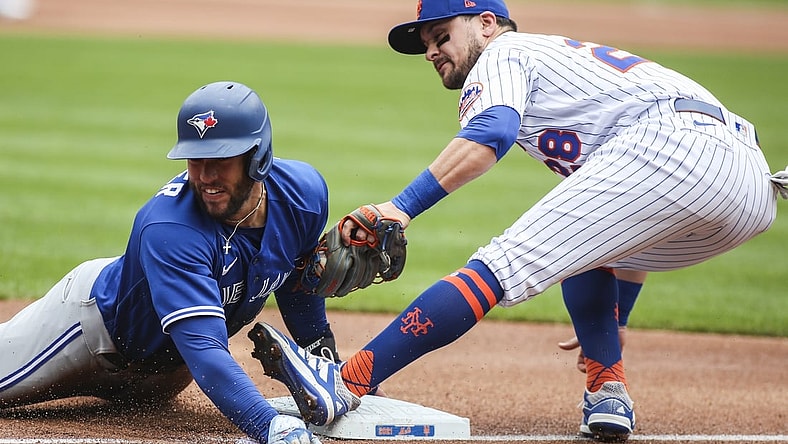 Jul 25, 2021; New York City, New York, USA;  Toronto Blue Jays center fielder George Springer (4) is tagged out trying to steal third base by New York Mets third baseman J.D. Davis (28) in the first inning at Citi Field. Mandatory Credit: Wendell Cruz-USA TODAY Sports