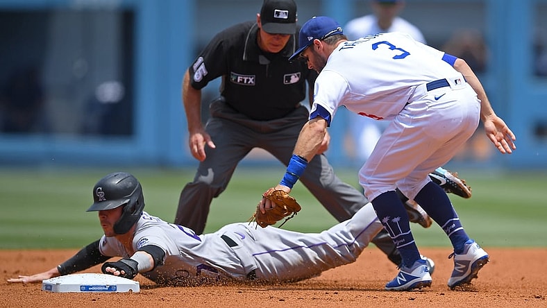 Jul 25, 2021; Los Angeles, California, USA;  Colorado Rockies shortstop Trevor Story (27) is tagged by Los Angeles Dodgers shortstop Chris Taylor (3) as he is caught in a run down play in the second inning at Dodger Stadium. Mandatory Credit: Jayne Kamin-Oncea-USA TODAY Sports