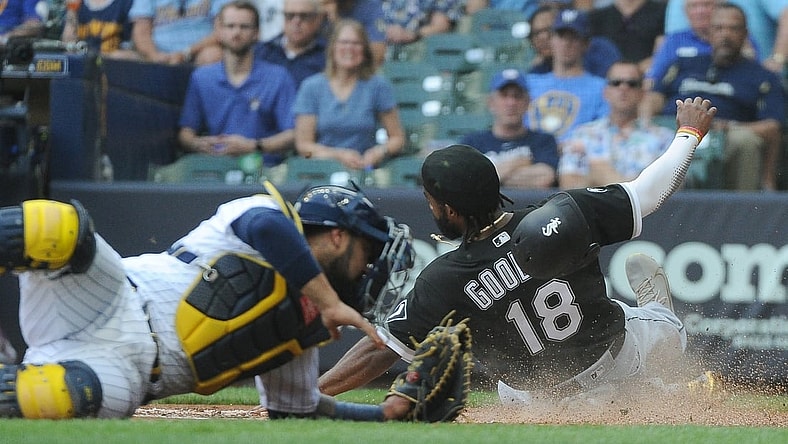 Jul 25, 2021; Milwaukee, Wisconsin, USA;  Chicago White Sox left fielder Brian Goodwin (18) slides safely into home against the Milwaukee Brewers in the second inning at American Family Field. Mandatory Credit: Michael McLoone-USA TODAY Sports