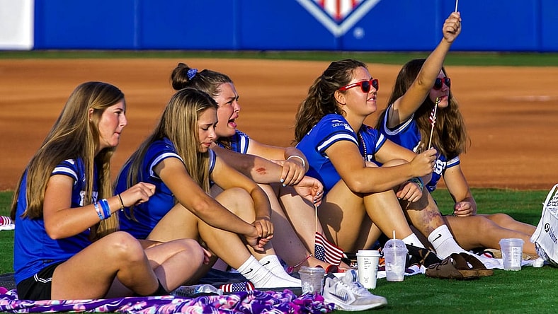 July 27, 2021; Oklahoma City, OK, USA; Members of the Finesse Fast Pitch team cheer on Team USA Softball as fans gather in the outfield of USA Softball Hall of Fame Stadium to watch the Olympic gold medal softball game between the United States and Japan on Tuesday, July 27, 2021, in Oklahoma City, Okla. Mandatory Credit: Chris Landsberger-USA TODAY NETWORK