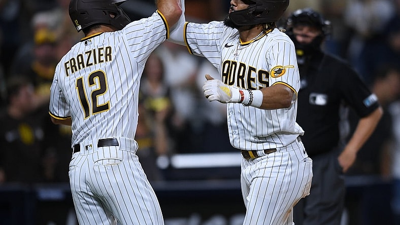 Jul 27, 2021; San Diego, California, USA; San Diego Padres shortstop Fernando Tatis Jr. (right) is congratulated by left fielder Adam Frazier (12) after hitting a two-run home run against the Oakland Athletics during the third inning at Petco Park. Mandatory Credit: Orlando Ramirez-USA TODAY Sports