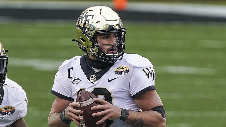 Dec 30, 2020; Charlotte, NC, USA; Wake Forest Demon Deacons quarterback Sam Hartman (10) drops back to pass against the Wisconsin Badgers during second half action at Bank of America Stadium. Mandatory Credit: Jim Dedmon-USA TODAY Sports