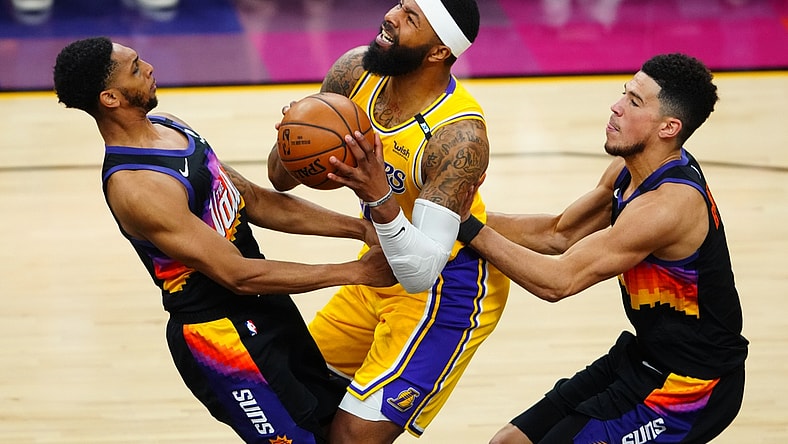 May 25, 2021; Phoenix, Arizona, USA; Los Angeles Lakers forward Markieff Morris (center) drives to the basket against Phoenix Suns guard Cameron Payne (left) and Devin Booker during game two of the first round of the 2021 NBA Playoffs at Phoenix Suns Arena. Mandatory Credit: Mark J. Rebilas-USA TODAY Sports