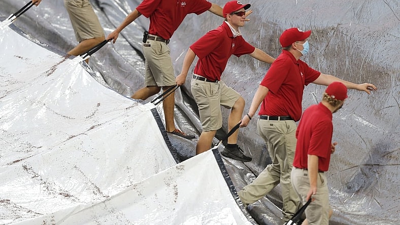 Jun 29, 2021; Cincinnati, Ohio, USA; Cincinnati Reds ground crew members uncover the field after a short rain delay prior to a game with the San Diego Padres and the Cincinnati Reds at Great American Ball Park. Mandatory Credit: David Kohl-USA TODAY Sports
