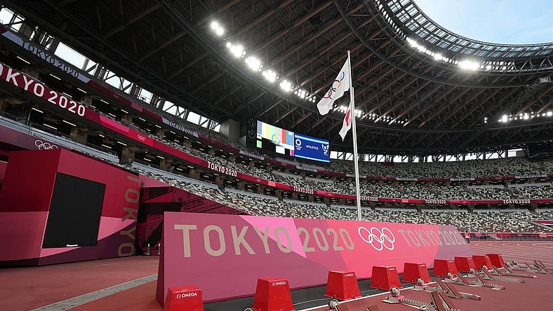 Jul 29, 2021; Tokyo, Japan; A general overall view of the starting blocks on the track and Olympic rings and Japan flags at New National Stadium, the venue for track and field and opening and closing ceremonies during the Tokyo 2020 Olympic Summer Games. Mandatory Credit: Kirby Lee-USA TODAY Sports