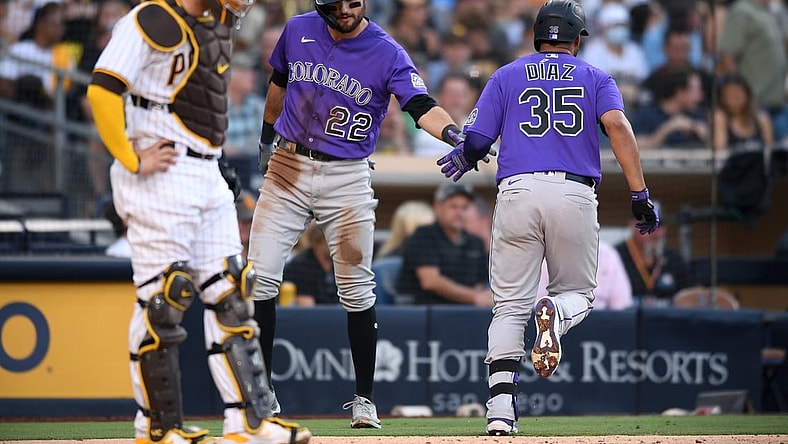 Jul 31, 2021; San Diego, California, USA; Colorado Rockies catcher Elias Diaz (35) is congratulated by center fielder Sam Hilliard (22) after hitting a home run during the fifth inning as San Diego Padres catcher Victor Caratini (left) looks on at Petco Park. Mandatory Credit: Orlando Ramirez-USA TODAY Sports