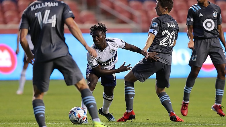 Jul 31, 2021; Sandy, Utah, USA; Vancouver Whitecaps midfielder Janio Bikel (19) and Minnesota United midfielder Will Trapp (20) play for a ball in the first half at Rio Tinto Stadium. Mandatory Credit: Rob Gray-USA TODAY Sports
