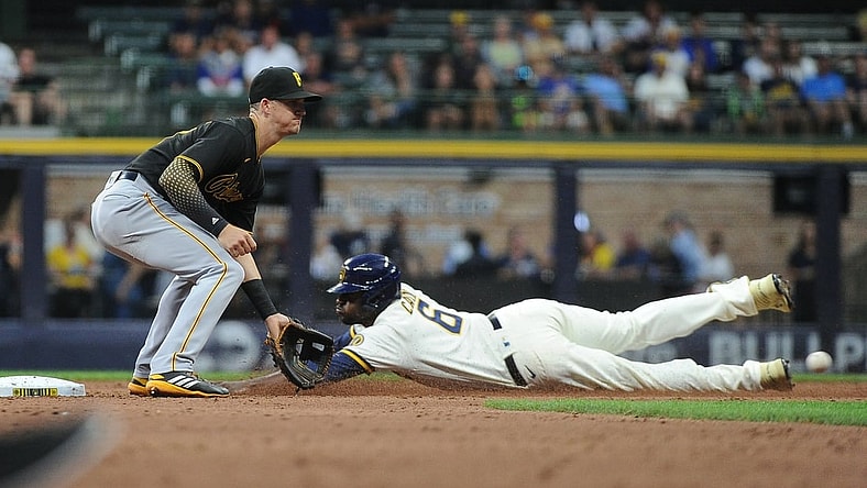 Aug 2, 2021; Milwaukee, Wisconsin, USA;  Milwaukee Brewers center fielder Lorenzo Cain (6) slides safely into second base ahead of the tag by Pittsburgh Pirates shortstop Kevin Newman (27) in the third inning at American Family Field. Mandatory Credit: Michael McLoone-USA TODAY Sports