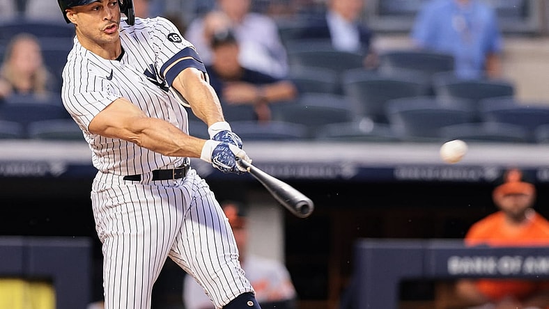 Aug 3, 2021; Bronx, New York, USA; New York Yankees designated hitter Giancarlo Stanton (27) hits an RBI single during the third inning against the Baltimore Orioles at Yankee Stadium. Mandatory Credit: Vincent Carchietta-USA TODAY Sports