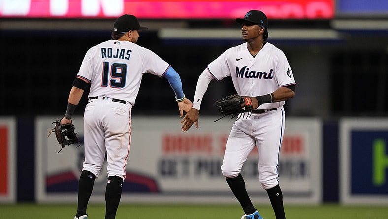 Aug 2, 2021; Miami, Florida, USA; Miami Marlins shortstop Miguel Rojas (19) and center fielder Lewis Brinson (25) celebrate after defeating the New York Mets at loanDepot park. Mandatory Credit: Jasen Vinlove-USA TODAY Sports