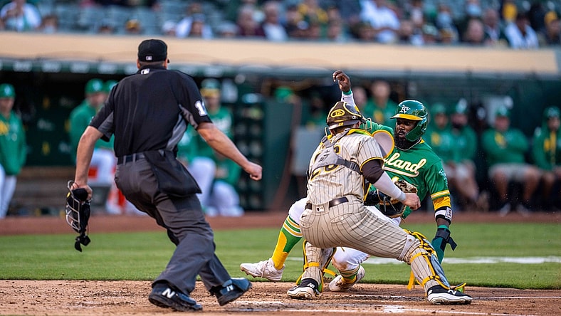 Aug 3, 2021; Oakland, California, USA; Oakland Athletics second baseman Josh Harrison (1) is tagged out at home plate by San Diego Padres catcher Austin Nola (26) during the second inning at RingCentral Coliseum. Mandatory Credit: Neville E. Guard-USA TODAY Sports
