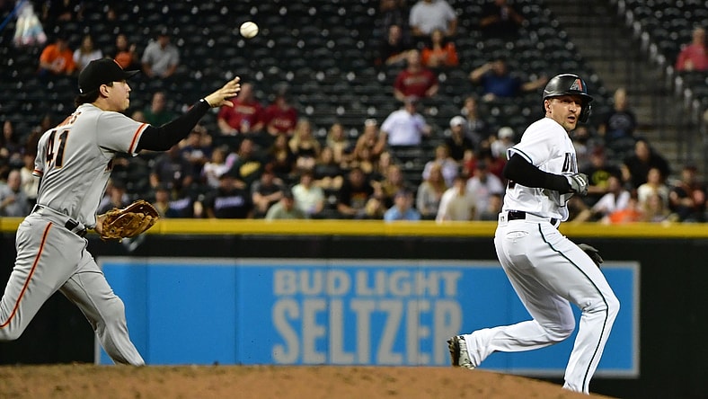 Aug 3, 2021; Phoenix, Arizona, USA; Arizona Diamondbacks shortstop Nick Ahmed (right) is caught in a run down by San Francisco Giants second baseman Wilmer Flores (41) in the fourth inning at Chase Field. Mandatory Credit: Matt Kartozian-USA TODAY Sports
