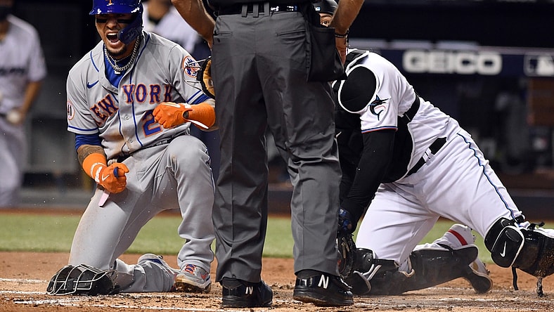 Aug 4, 2021; Miami, Florida, USA; New York Mets shortstop Javier Baez (23) celebrates after scoring a run against Miami Marlins catcher Alex Jackson (right) during the second inning at loanDepot Park. Mandatory Credit: Jim Rassol-USA TODAY Sports