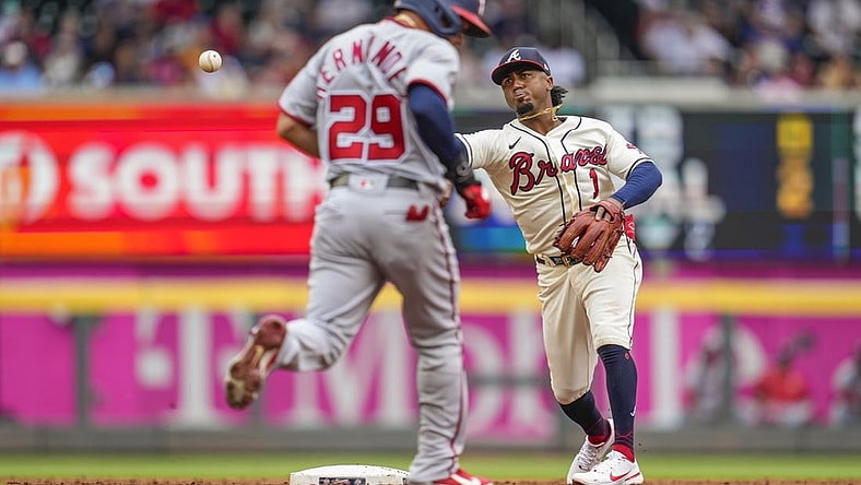 Aug 8, 2021; Cumberland, Georgia, USA; Atlanta Braves second baseman Ozzie Albies (1) throws for a double play past Washington Nationals outfielder Yadiel Hernandez (29) during the first inning at Truist Park. Mandatory Credit: Dale Zanine-USA TODAY Sports