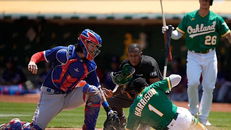 Aug 8, 2021; Oakland, California, USA; Oakland Athletics second baseman Josh Harrison (1) slides in safe against Texas Rangers catcher Jonah Heim (28) during the first inning at RingCentral Coliseum. Mandatory Credit: Stan Szeto-USA TODAY Sports