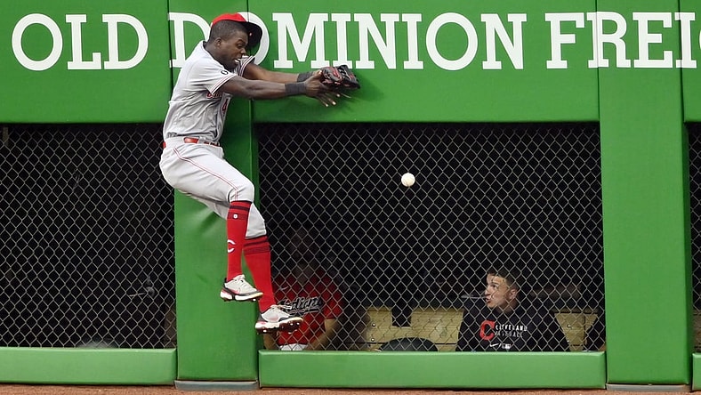 Aug 9, 2021; Cleveland, Ohio, USA; Cincinnati Reds center fielder Aristides Aquino (44) collides with the wall while running after a ball hit for a RBI triple by Cleveland Indians third baseman Jose Ramirez (not pictured) in the third inning at Progressive Field. Mandatory Credit: David Richard-USA TODAY Sports