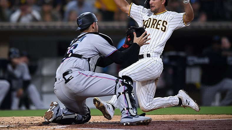 Aug 9, 2021; San Diego, California, USA; San Diego Padres second baseman Adam Frazier (right) is tagged out at home by Miami Marlins catcher Alex Jackson (23) during the third inning at Petco Park. Mandatory Credit: Orlando Ramirez-USA TODAY Sports