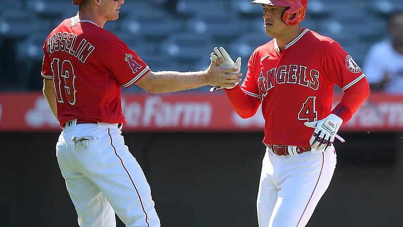 Aug 10, 2021; Anaheim, California, USA;  Los Angeles Angels second baseman Phil Gosselin (13) and shortstop Jose Iglesias (4) score on a single by left fielder Justin Upton (not pictured) singles in two runs in the third inning of the game against the Toronto Blue Jays at Angel Stadium. Mandatory Credit: Jayne Kamin-Oncea-USA TODAY Sports