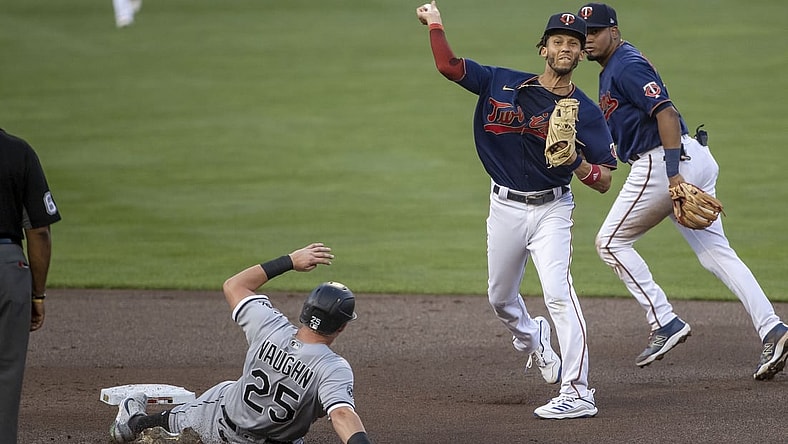 Aug 10, 2021; Minneapolis, Minnesota, USA; Minnesota Twins shortstop Andrelton Simmons (9) turns a double play over Chicago White Sox left fielder Andrew Vaughn (25) in the second inning at Target Field. Mandatory Credit: Jesse Johnson-USA TODAY Sports