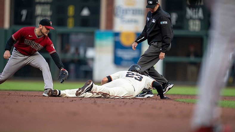 Aug 11, 2021; San Francisco, California, USA;  San Francisco Giants third baseman Kris Bryant (23) dives back into second base as Arizona Diamondbacks second baseman Josh VanMeter (19) attempts to tag him out during the first inning at Oracle Park. Mandatory Credit: Neville E. Guard-USA TODAY Sports