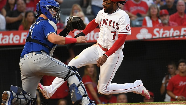 Aug 12, 2021; Anaheim, California, USA;  Los Angeles Angels center fielder Jo Adell (7) scores on a sacrifice fly by catcher Kurt Suzuki (24) (not pictured) past Toronto Blue Jays catcher Reese McGuire (7) in the second inning  at Angel Stadium. Mandatory Credit: Richard Mackson-USA TODAY Sports