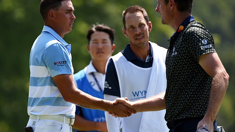 Aug 13, 2021; Greensboro, North Carolina, USA; Justin Rose (far right) shakes hands with Rickie Fowler after completing  the second round of the Wyndham Championship golf tournament. Mandatory Credit: Rob Kinnan-USA TODAY Sports