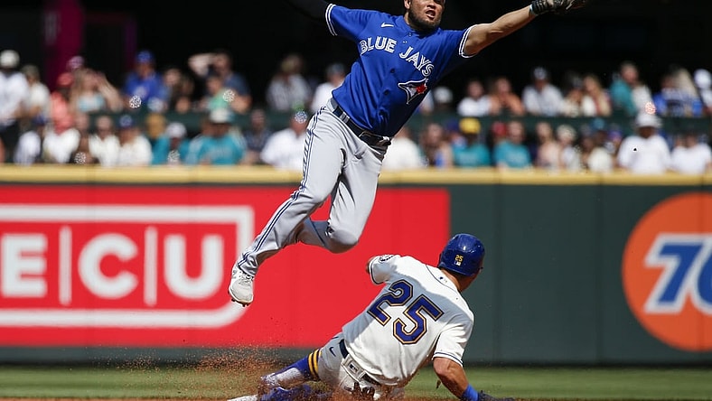 Aug 15, 2021; Seattle, Washington, USA; Toronto Blue Jays second baseman Breyvic Valera (74) catches a throw as Seattle Mariners left fielder Dylan Moore (25) steals second base during the second inning at T-Mobile Park. Mandatory Credit: Joe Nicholson-USA TODAY Sports