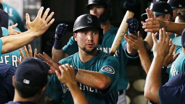 Aug 17, 2021; Arlington, Texas, USA; Seattle Mariners catcher Cal Raleigh (29) is greeted in the dugout after scoring against the Texas Rangers during the fifth inning at Globe Life Field. Mandatory Credit: Raymond Carlin III-USA TODAY Sports