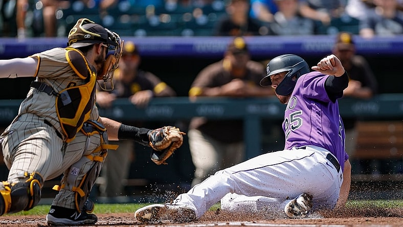 Aug 18, 2021; Denver, Colorado, USA; Colorado Rockies first baseman C.J. Cron (25) slides safely into home against San Diego Padres catcher Austin Nola (26) in the first inning at Coors Field. Mandatory Credit: Isaiah J. Downing-USA TODAY Sports