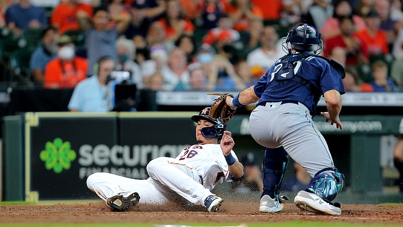 Aug 21, 2021; Houston, Texas, USA; Houston Astros left fielder Taylor Jones (28) beats a tag by Seattle Mariners catcher Cal Raleigh (29) while sliding into home plate to score a run during the fifth inning at Minute Maid Park. Mandatory Credit: Erik Williams-USA TODAY Sports