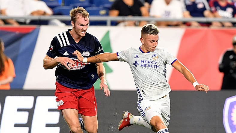 Aug 21, 2021; Foxborough, Massachusetts, USA; FC Cincinnati midfielder Alvaro Barreal (31) attempts a shot in front of New England Revolution defender Henry Kessler (4) during the first half at Gillette Stadium. Mandatory Credit: Brian Fluharty-USA TODAY Sports