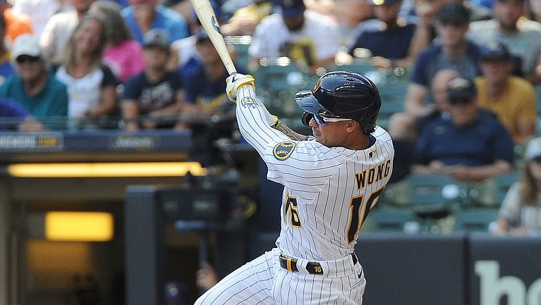 Aug 22, 2021; Milwaukee, Wisconsin, USA; Milwaukee Brewers second baseman Kolten Wong (16) hits a triple to score two run against the Washington Nationals in the fourth inning at American Family Field. Mandatory Credit: Michael McLoone-USA TODAY Sports