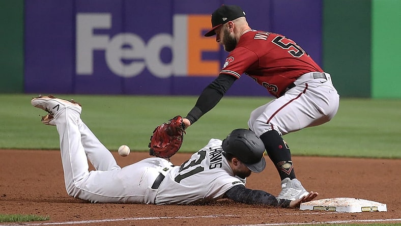 Aug 25, 2021; Pittsburgh, Pennsylvania, USA;  Pittsburgh Pirates second baseman Michael Chavis (31) dives back safely to first base as Arizona Diamondbacks first baseman Christian Walker (53) takes a pick-off attempt how during the fifth inning at PNC Park. Mandatory Credit: Charles LeClaire-USA TODAY Sports