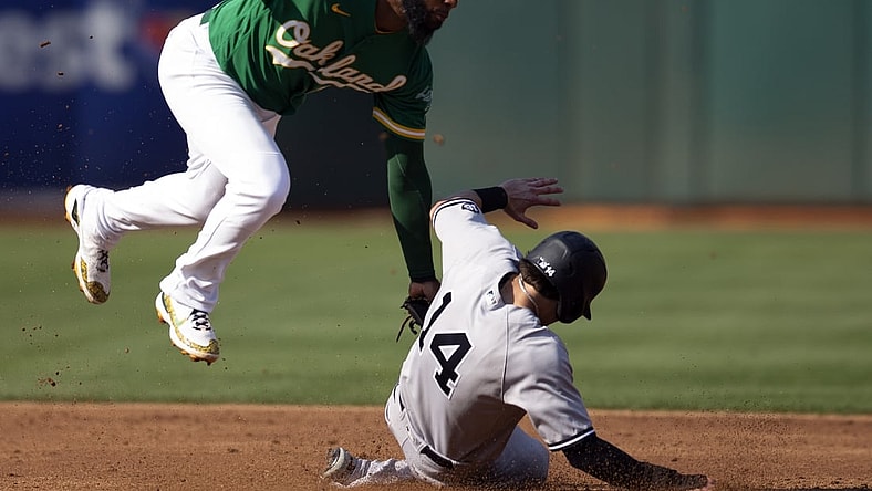 Aug 29, 2021; Oakland, California, USA; Oakland Athletics shortstop Elvis Andrus (17) leaves his feet to tag out New York Yankees shortstop Tyler Wade (14) on a stolen base attempt during the third inning at RingCentral Coliseum. Mandatory Credit: D. Ross Cameron-USA TODAY Sports