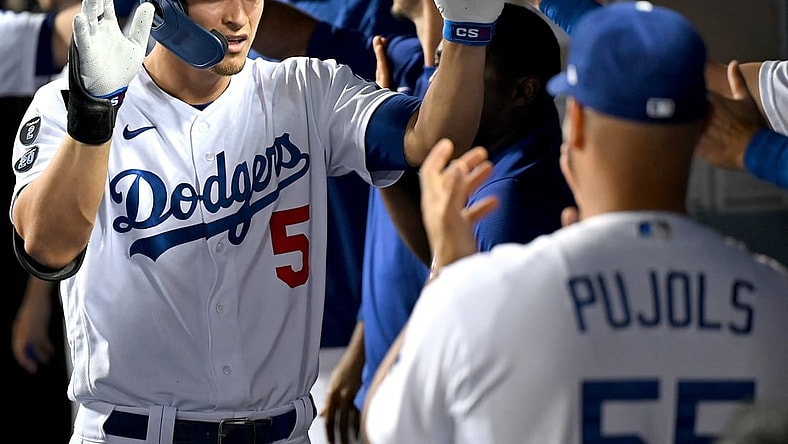 Aug 30, 2021; Los Angeles, California, USA;  Los Angeles Dodgers shortstop Corey Seager (5) is greeted in the dugout after hitting a two run home scoring left fielder AJ Pollock (11) run in the third inning of the game against the Atlanta Braves at Dodger Stadium. Mandatory Credit: Jayne Kamin-Oncea-USA TODAY Sports