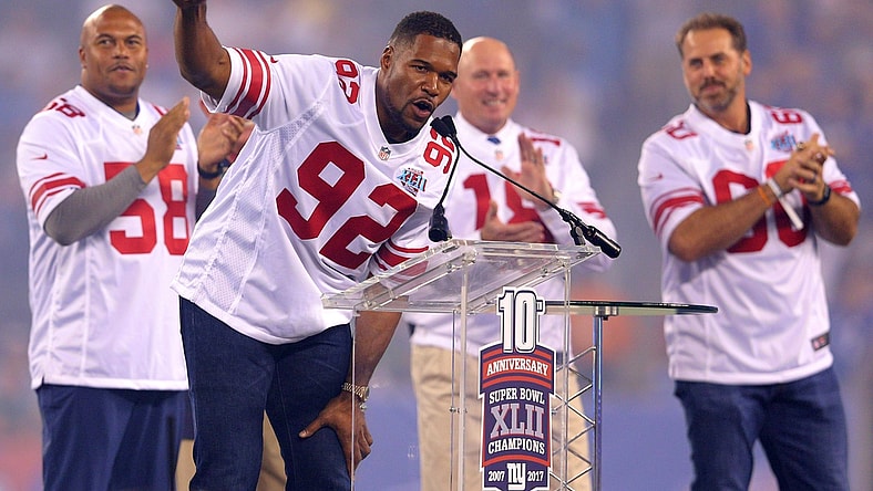 Sep 18, 2017; East Rutherford, NJ, USA; Former New York Giants player Michael Strahan speaks in front of former players Antonio Pierce (58) and Jeff Feagles (18) and Shaun O'Hara (60) during a halftime ceremony honoring the 2007 Super Bowl champion Giants during a game against the Detroit Lions at MetLife Stadium. Mandatory Credit: Brad Penner-USA TODAY Sports