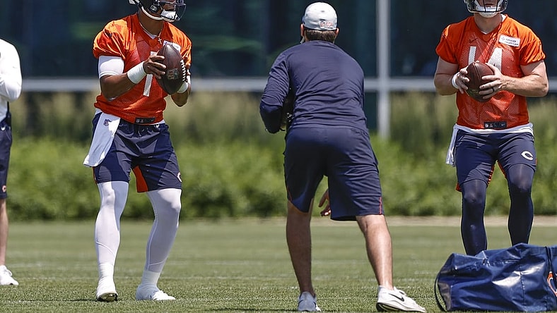 Jun 9, 2021; Lake Forest, Illinois, USA; Chicago Bears quarterbacks Justin Fields (1) and Andy Dalton (14) look to pass footballs during organized team activities at Halas Hall. Mandatory Credit: Kamil Krzaczynski-USA TODAY Sports