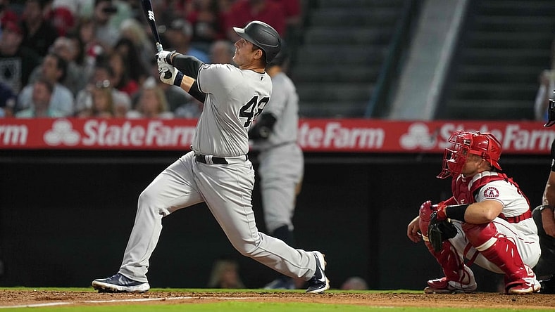 Aug 31, 2021; Anaheim, California, USA; New York Yankees first baseman Anthony Rizzo (48) follows through on a solo home run in the fourth inning as Los Angeles Angels catcher Max Stassi (33) watches at Angel Stadium. Mandatory Credit: Kirby Lee-USA TODAY Sports