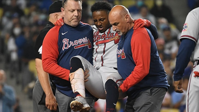 Aug 31, 2021; Los Angeles, California, USA; Atlanta Braves second baseman Ozzie Albies (1) is helped to the clubhouse after hitting his knee with a foul ball hit during the fifth inning at Dodger Stadium. Mandatory Credit: Richard Mackson-USA TODAY Sports